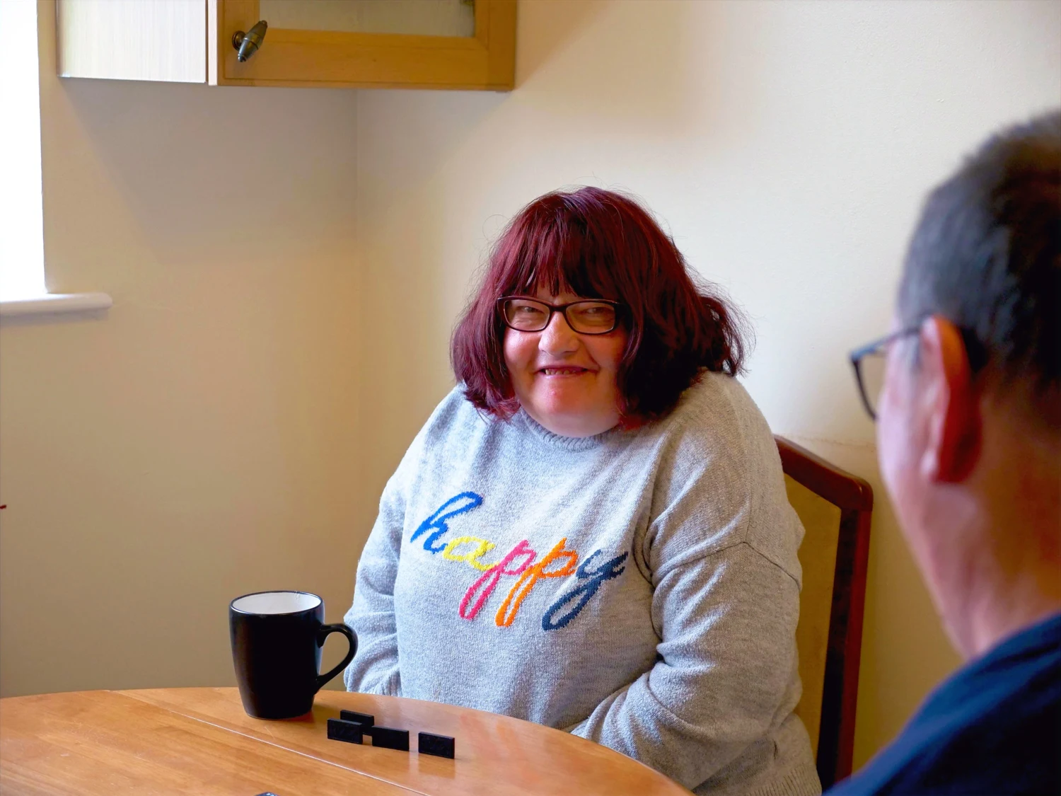 A woman enjoying a conversation over a cup of tea